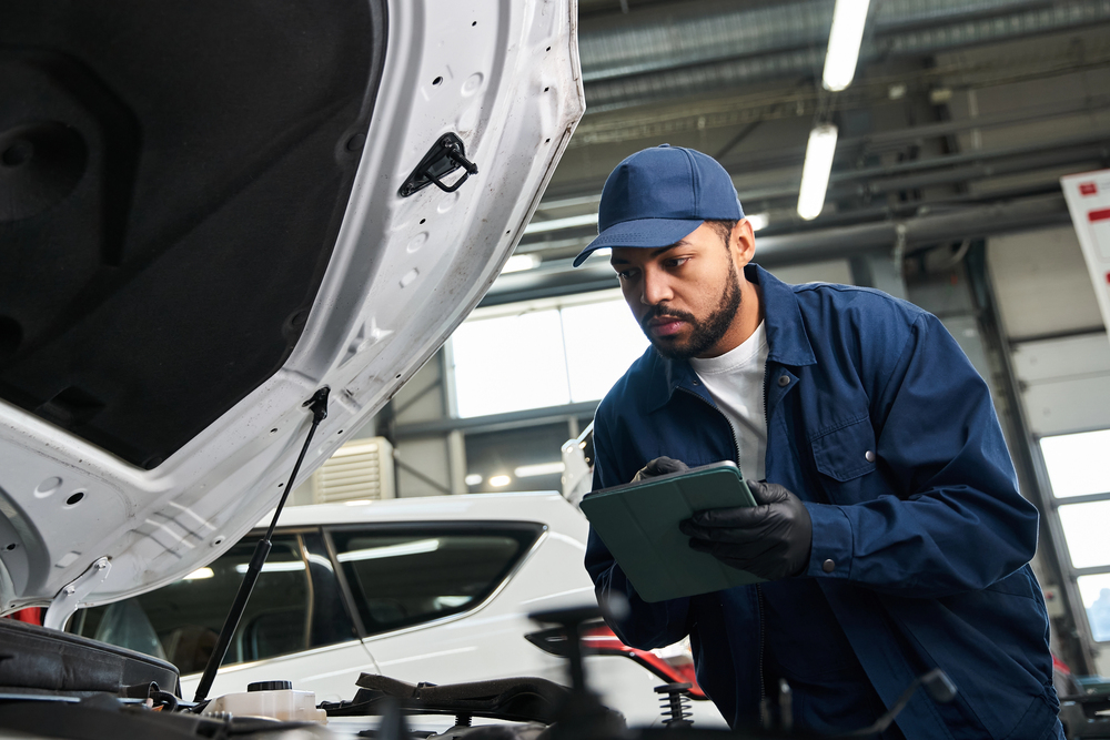 Mechaniker prüft ein Auto bei der Inspektion in der Werkstatt